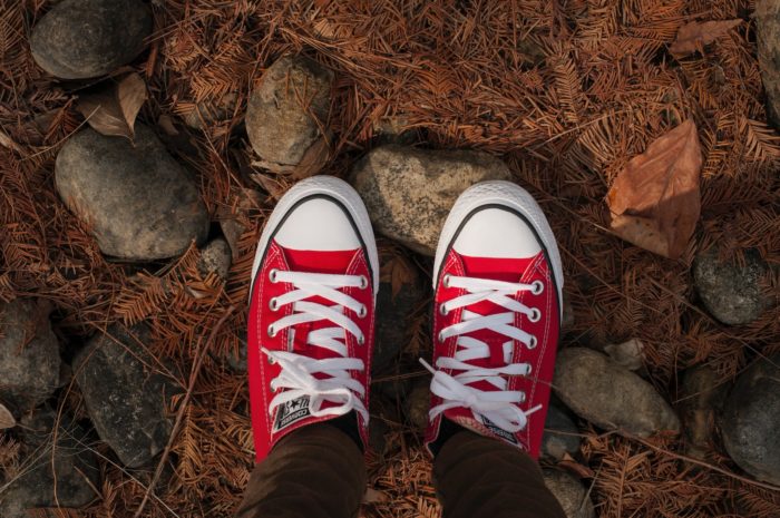 person wearing red and white converse all star low top sneakers
